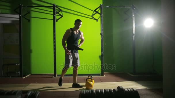 Hombre atlético joven haciendo ejercicio de swing kettlebell en el gimnasio. CrossFit — Vídeo de stock