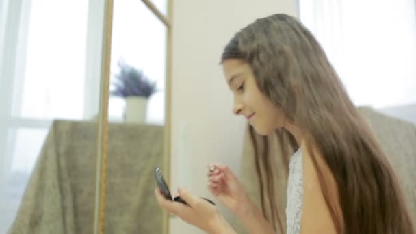Niña se pinta delante de un espejo de maquillaje de sus madres — Vídeo de stock