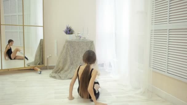 Liten flicka i en baddräkt gym repeterar hemma framför en spegel — Stockvideo