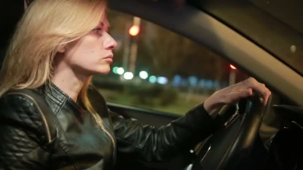 Bionda giovane donna alla guida di una macchina di notte — Video Stock