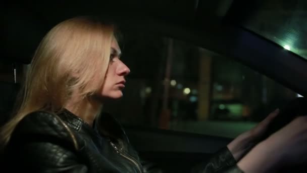 Jonge vrouw Blondie besturen van een auto in de nacht — Stockvideo