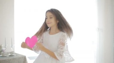 Kırmızı kalp gösterilen mutlu gülümseyen kız. Sevgililer günü