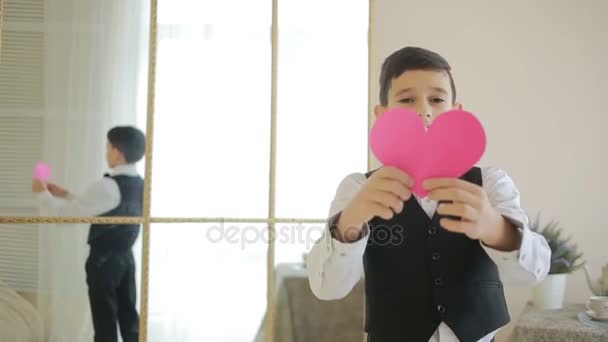 Velmi šťastný usměvavý chlapec ukazuje červené srdce. valentinky den, — Stock video