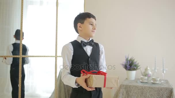 Gadstuke радостный мальчик в галстуке-бабочке держа подарок с — стоковое видео