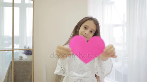 赤いハートを示す幸せな笑顔の女の子。バレンタインの日 — ストック動画