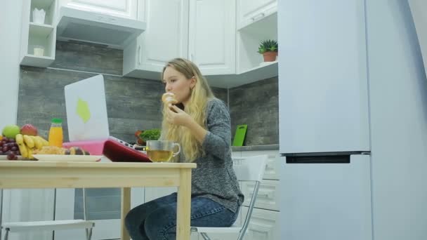 A csinos szőke lány evés és ivás, egészséges étel otthon, egészségügyi koncepció — Stock videók