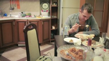 Akşamdan mutfak masasında olan genç adam. partiden sonra