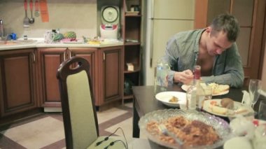 Akşamdan mutfak masasında olan genç adam. partiden sonra