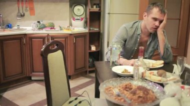 Akşamdan mutfak masasında olan genç adam. partiden sonra