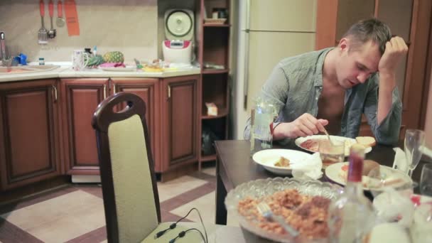 Jovem com uma ressaca na mesa na cozinha. após a festa — Vídeo de Stock