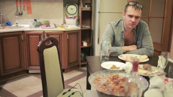 Молодий чоловік з похміллям за столом на кухні. після вечірки — стокове відео