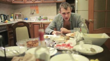 Akşamdan mutfak masasında olan genç adam. partiden sonra