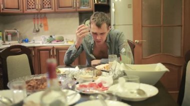 Akşamdan mutfak masasında olan genç adam. partiden sonra