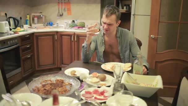 Jonge man met een kater aan de tafel in de keuken. afterparty — Stockvideo