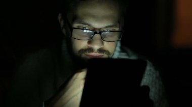 gözlük ve bir kazak karanlıkta bir tablet ile adam