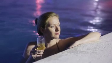 Havuzun termal su bir bardak şampanya ile gece kadın