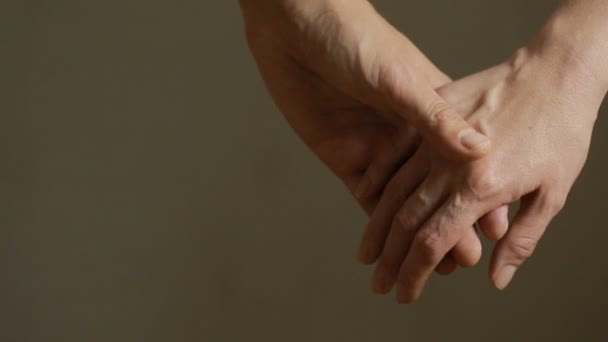 Крупним планом чоловік і жінка торкаються руки, тримаючись разом на розмитому фоні . — стокове відео