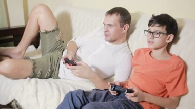 Baba ve oğul video onların evde kanepede oyna