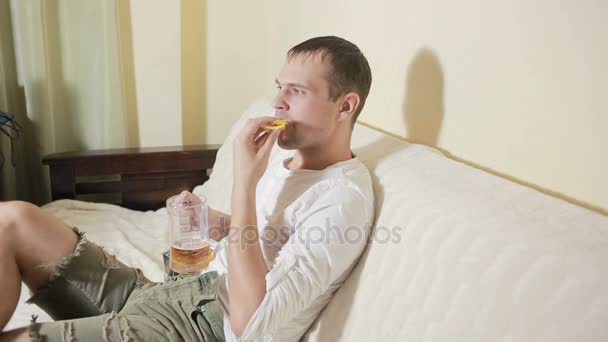 若い男家のソファでテレビを見てビールを飲み — ストック動画