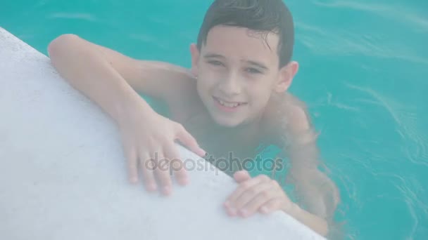 Геотермальный курорт. Мальчик-подросток отдыхает в бассейне с горячей водой . — стоковое видео