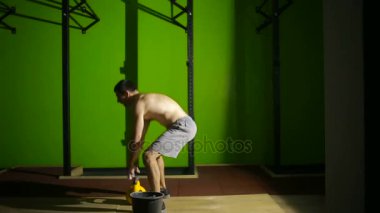 Kettlebell salıncak egzersiz spor yapan genç atletik erkek. CrossFit