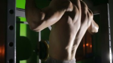 Gömleksiz adam yatay bir çubuk üzerinde Mide Egzersizleri yapıyor. CrossFit. egzersiz