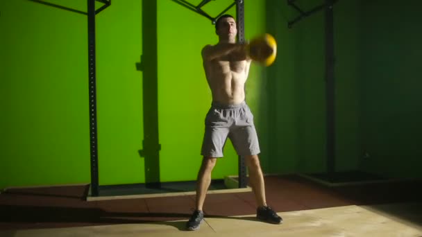 Jovem atlético fazendo kettlebell swing no ginásio. CrossFit — Vídeo de Stock