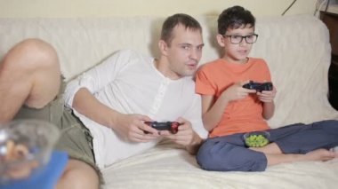 Baba ve oğul video onların evde kanepede oyna