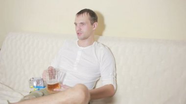 ev kanepe ve televizyon izlerken içki bira genç adam