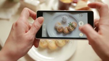 Hareket eden telefon fotoğraf makinesi ile fotoğraf gıda yapmak bir restoranda trendy adam