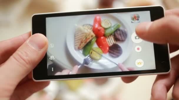 Trendy man in een restaurant maken de foto's voor voedsel met mobiele telefooncamera — Stockvideo