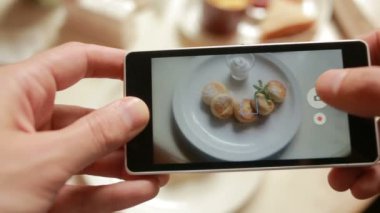 Hareket eden telefon fotoğraf makinesi ile fotoğraf gıda yapmak bir restoranda trendy adam