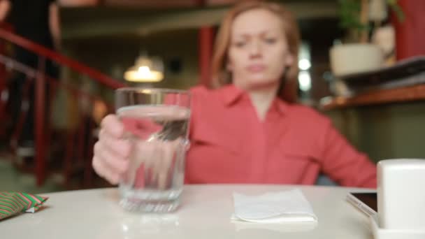 Woman in restaurant in anticipation of drinking water — Stock Video