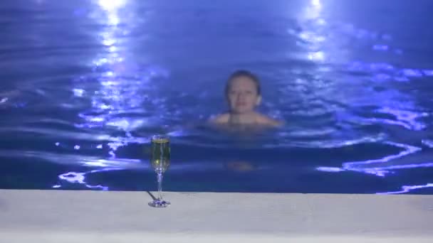 Kvinna på natten i poolen med termalvatten med ett glas champagne — Stockvideo