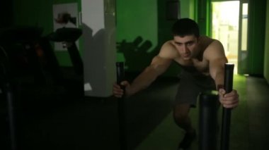 adam jimnastik egzersizleri gerçekleştirir. önünde, platform iterek powerlifting