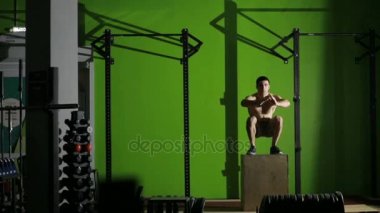 kaslı adam bir kutu atlama yapıyor. spor salonu. CrossFit