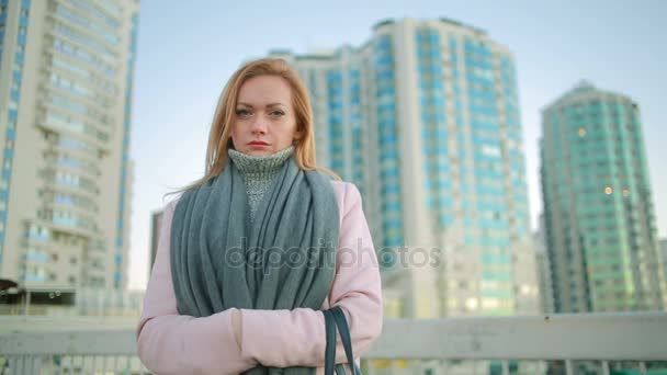 Ragazza in un cappotto rosa cammina su una città moderna sullo sfondo di grattacieli — Video Stock