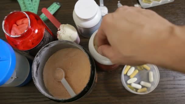 Eiwitten, bcaa, omega3 in pillen op houten achtergrond. Sport voeding concept — Stockvideo