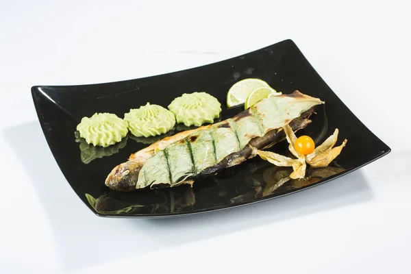 Pesce saporito con verdure e limone sul tavolo della cucina — Foto Stock