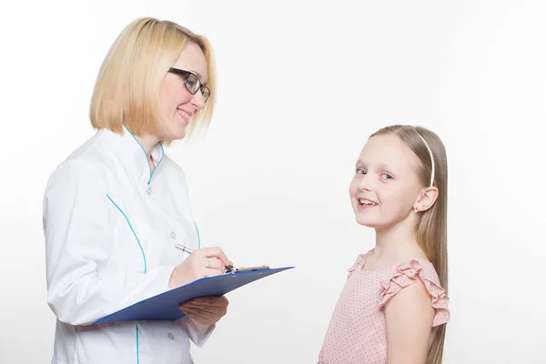 Läkaren och en leende flicka patient. isolerad på vit bakgrund — Stockfoto