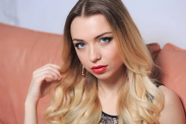 Beautiful blond hair woman sitting on the couch — Stock Photo, Image