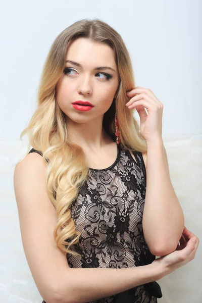 Beautiful blond hair woman sitting on the couch — Stock Photo, Image