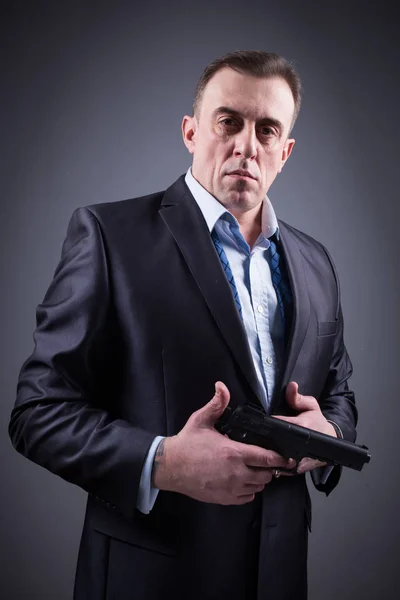 Homem em terno de negócios com uma arma — Fotografia de Stock
