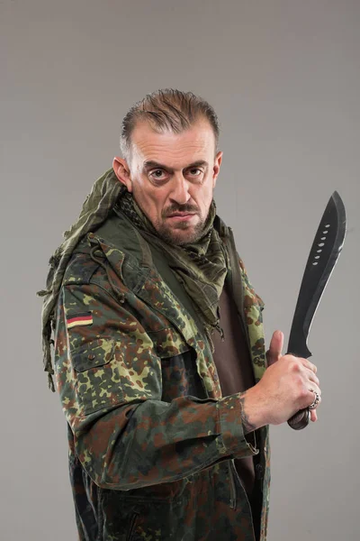Hombre en uniforme de soldado sosteniendo cuchillo — Foto de Stock