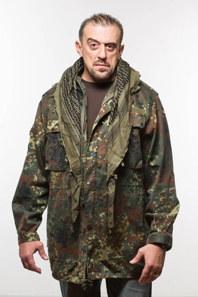 Adulto asustadizo hombre en una camuflaje chaqueta. una persona peligrosa . — Foto de Stock