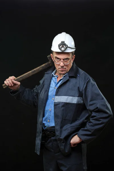 Minero de carbón mostrando terrón de carbón con pulgares hacia arriba contra una oscuridad — Foto de Stock