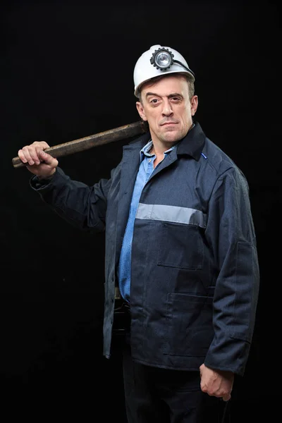 Coal miner showing lump of coal with thumbs up against a dark — Stock Photo, Image