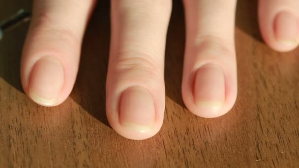 Närbild av en ung kvinna som målar sin egen naglar med pearl lack på bord — Stockvideo