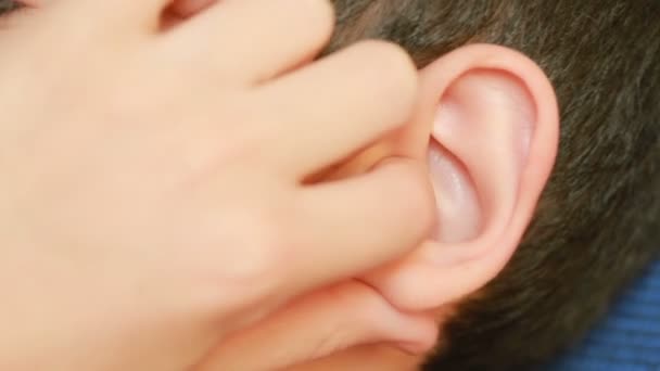 Oído de niño humano de cerca. dolor de oído, otitis. El niño toca una oreja dolorida — Vídeos de Stock