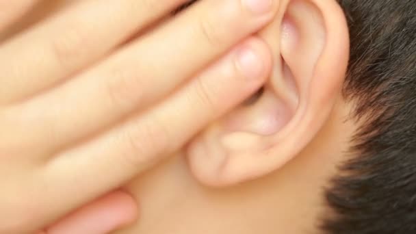 Oído de niño humano de cerca. dolor de oído, otitis. El niño toca una oreja dolorida — Vídeo de stock